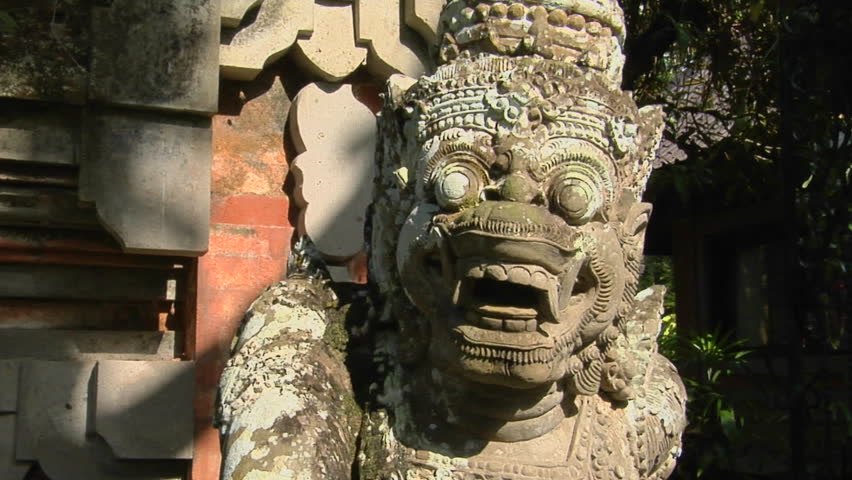 A Balinese God stone carving guards a temple