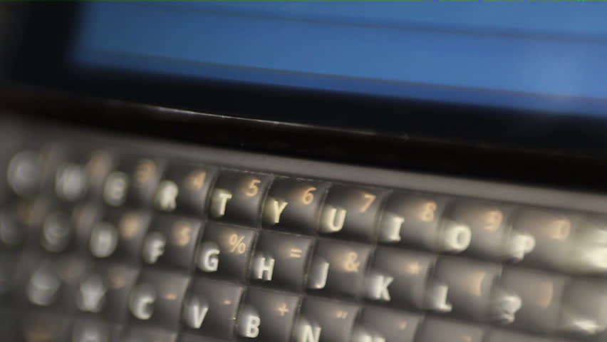 HD macro toy lens / selective focus footage of a QWERTY smart phone, with the message "LOL" being texted on it.