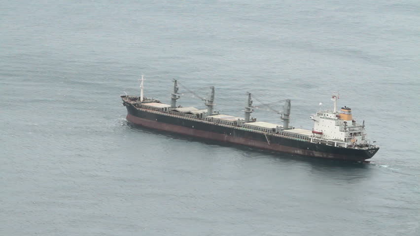 Cargo and oil tankers anchored of coast of Gibraltar in the Mediterranean Sea leaving port. In an area contested over ownership between Spain and England. Red and white boats or ships
