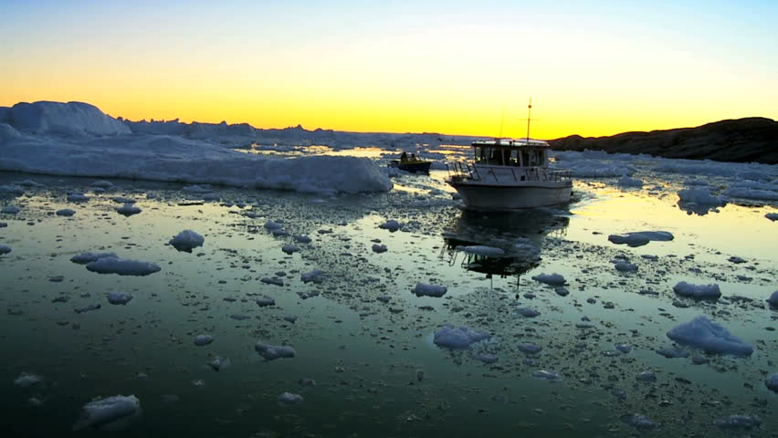 Nautical vessel at sunset in ice floes with icebergs