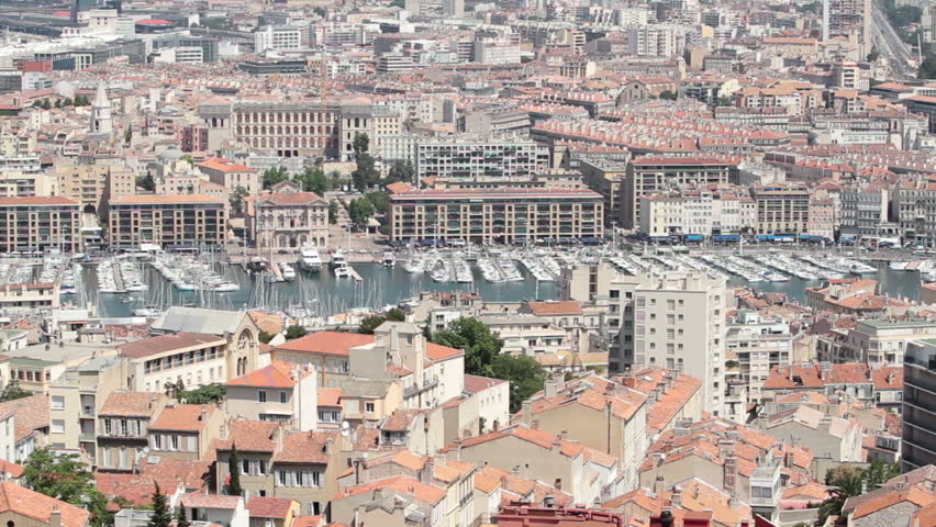 Marseille France close pan across city from above at Basilica Notre Dame de la Garde. Downtown, marina and fort along coast of Mediterranean Sea.