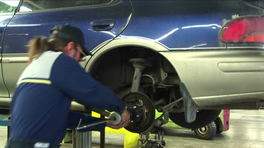 CHICAGO, IL - CIRCA 2005: A mechanic pulls repeatedly on a wheel's axle in Chicago, Il circa 2005.