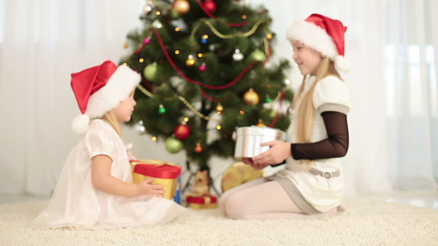 Happy sisters give each other Christmas gifts 