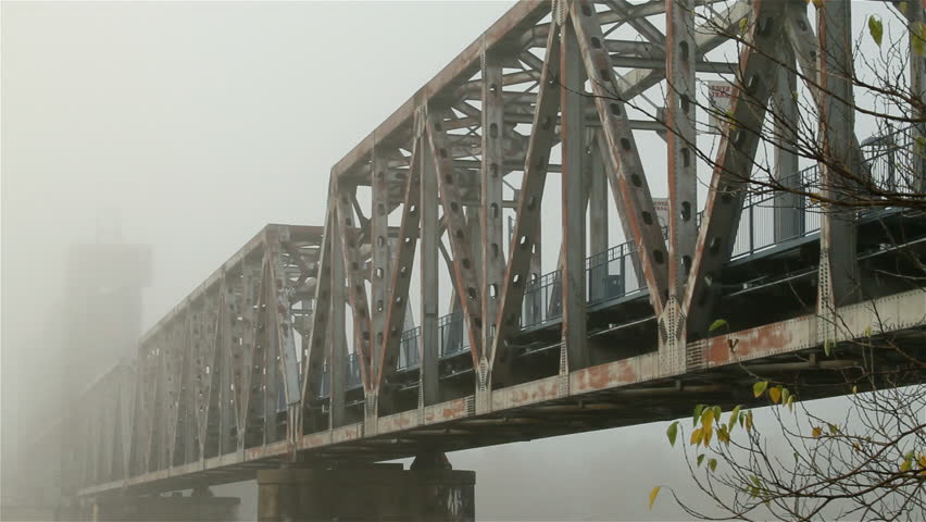 Pan of bridge in heavy fog.