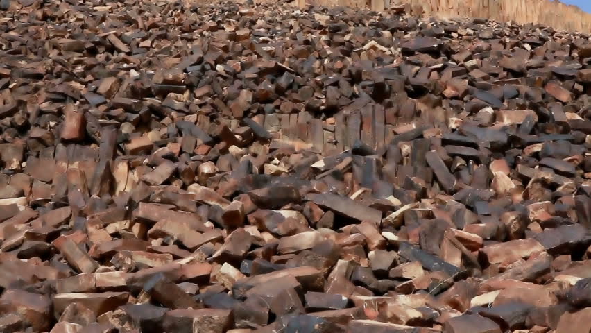 Low angled tilt-up of the rocky hillside to blue sky at Ha-Minsara (The Carpentry Shop), a geological formation in the Mitzpe Ramon Crater in Israel. 