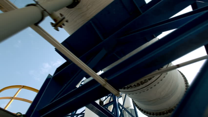 Dolly shot looking up at pipes with the sun shining through on the right side if the pipes at the IDE Ashkelon desalination plant in Israel.