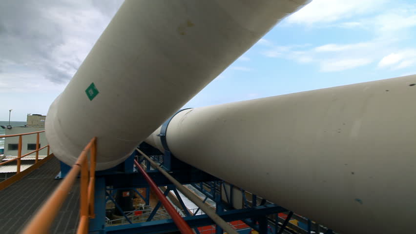 Slider dolly move left to right under a white water pipe and into another huge white pipe on the right frame at the IDE Ashkelon desalination Plant in Israel.
