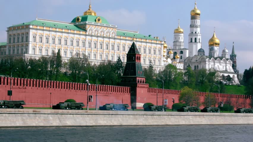 Katushas motorcade ride by quay of Moscow Kremlin, red brick walls and Ivan Great Bell Tower. Victory Day 1945 year. Russia.