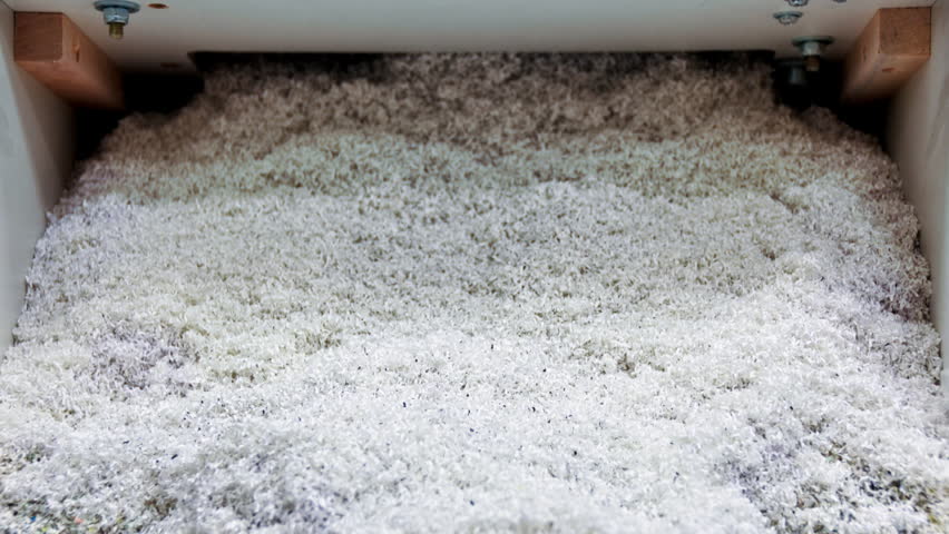 a document shredder spews endless shreds of multi-colored paper