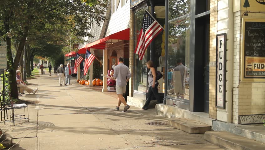 COOPERSTOWN, NY - SEPT 24, 2011: People stroll down the sidewalk of the main street on September 24, 2011 in Cooperstown.