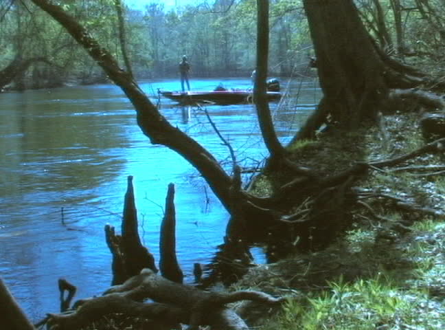 A motor boat whizzes by a fisherman's boat.