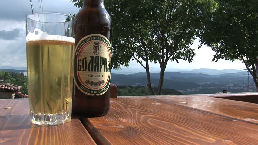 PLOVDIV, BULGARIA - CIRCA MAY 2007: A Bulgarian beer sits on a table overlooking a valley and mountains circa May 2007 in Plovdiv.