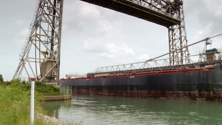 Ship moving under Vertical lift bridge along the Welland Canal toward Lake Ontario, Welland, Ontario, Canada.