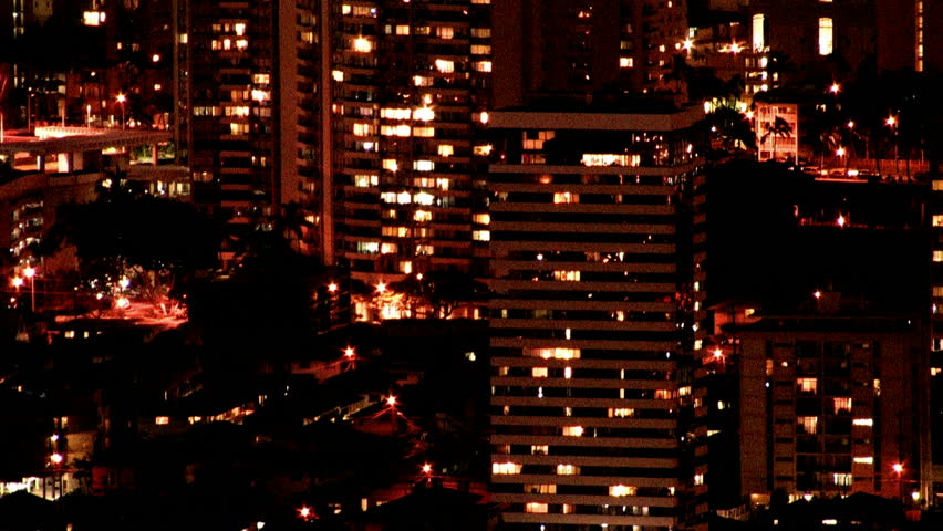 City of Honolulu and Waikiki Beach, Oahu, Hawaii at night. Dark sky with bright colorful lights. Roads, buildings and ball park. Very scenic view looking down on city. Zoom effect is outstanding.