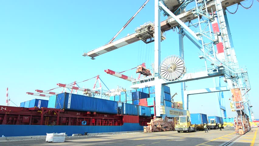 ASHDOD ISRAEL - DECEMBER 19: A cargo ship is loaded and unloaded by container crane in Ashdod seaport, Israel on December 19 2011.