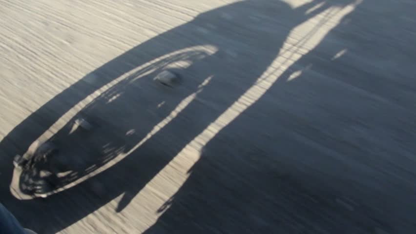 Shadow of Motorbike running on gravel road