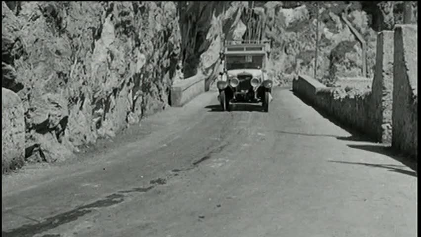 Vintage car driving off mountain and crashing into ocean