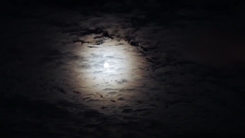 Moonlit night with fleecy clouds passes on dark blue sky, timelapse video