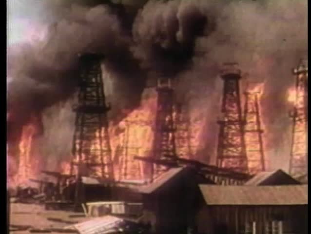 Wide shot oil well fire at oil refinery