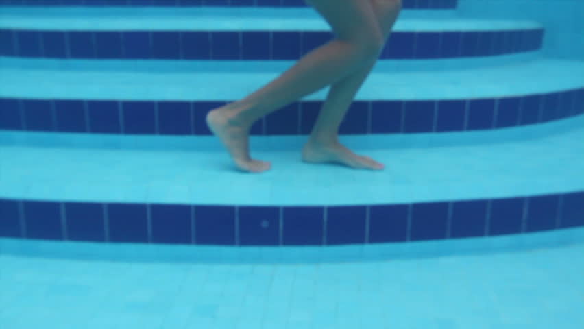 beautiful woman dances in a swimming pool. shot with the camera submerged in the water