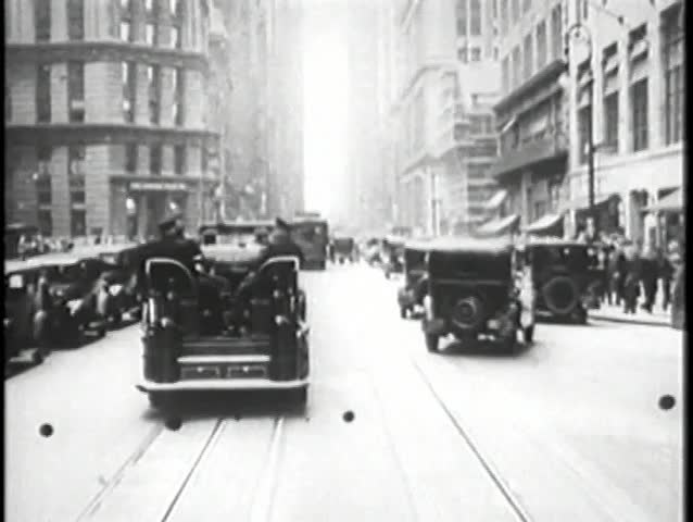 Police car chase through New York City streets, 1930s