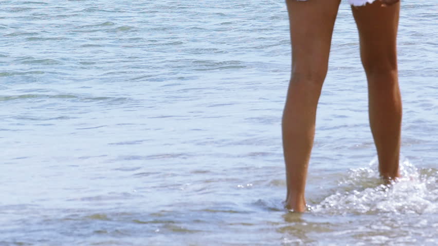 Slow Motion Of Bare Female Legs On The Beach Waves Splashing In Them