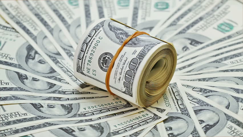 Rotating bundle of many rolled up 100 dollar bank notes on a money background  