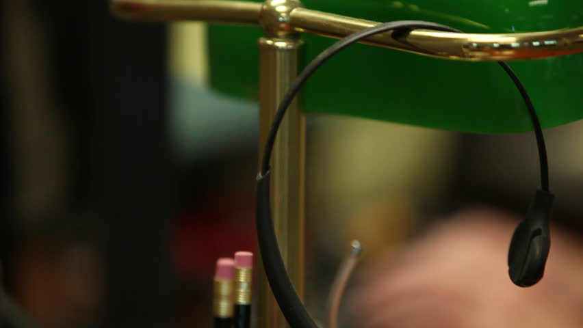 Dolly shot moving from a receptionist's headset to a pair of hands typing.