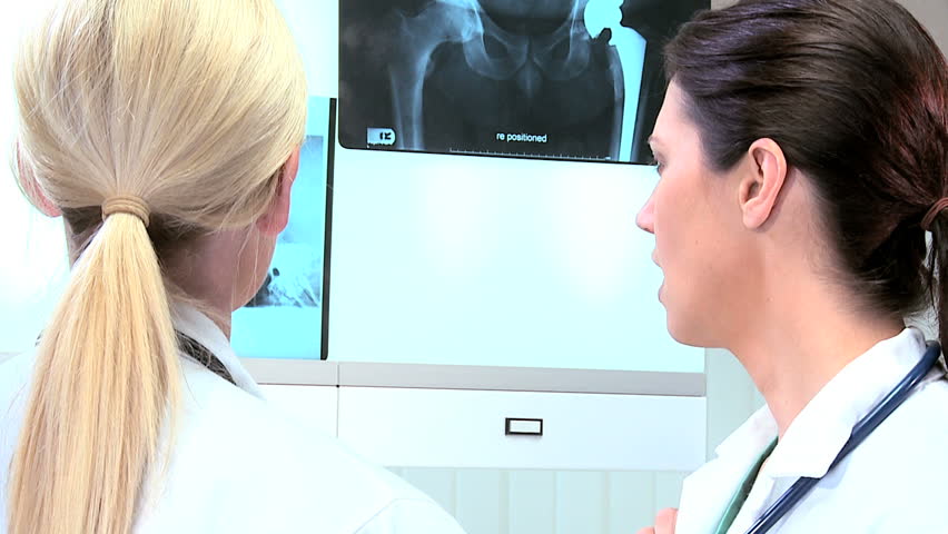 Young female doctors in hospital radiology department inspecting x-rays