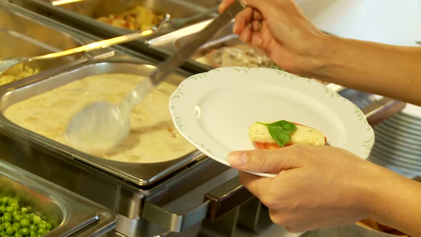 Restaurant guests select food from a buffet