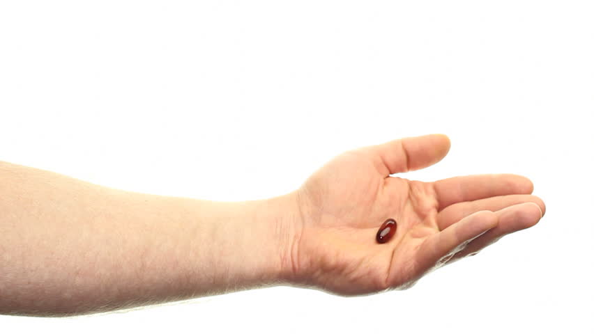 Caucasian hand showing one dose of a flax seed oil soft gel supplement in front of a white background, moving around a little and then withdrawing hand to the left.
