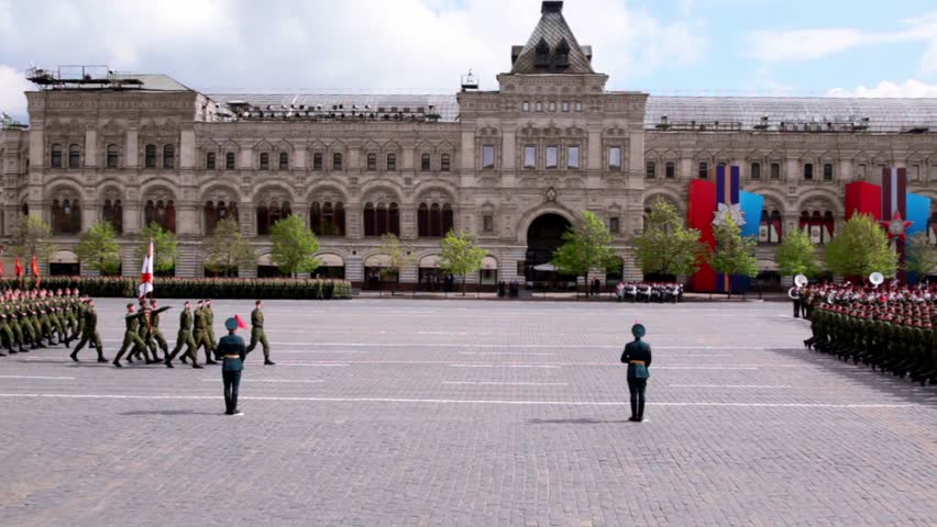 Military ranks march with guns on Red square on Victory Parade at background of gum