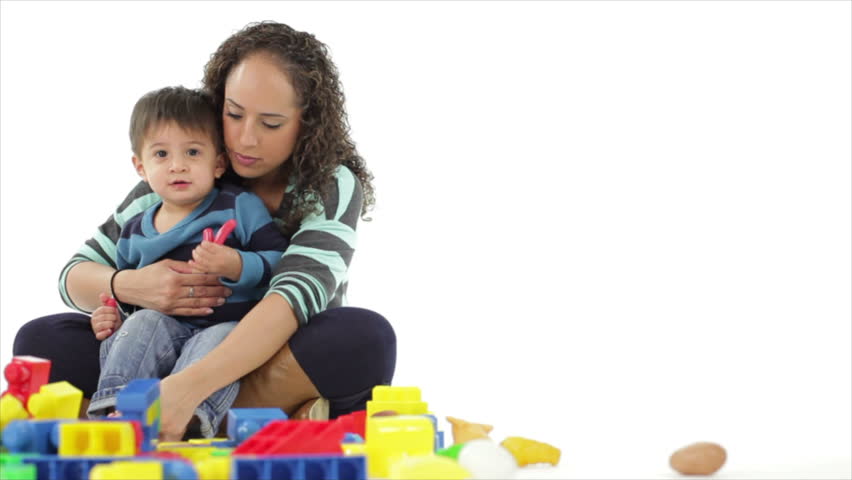 A pretty Hispanic mother struggles to keep her happy little toddler interested in some colorful blocks.