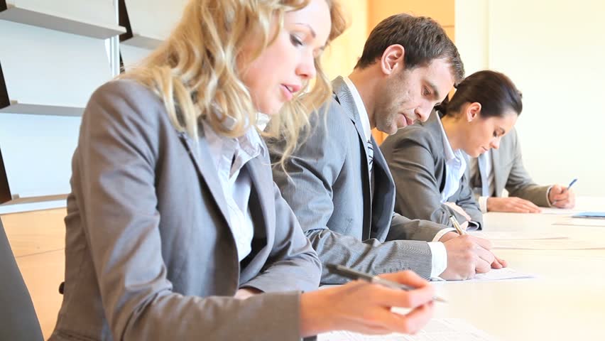 Young business people signing application form