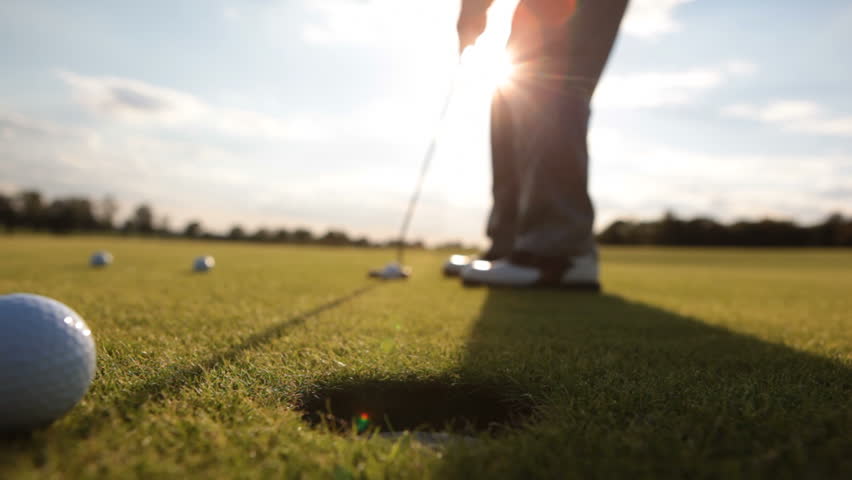 Golf player strikes ball on golf course