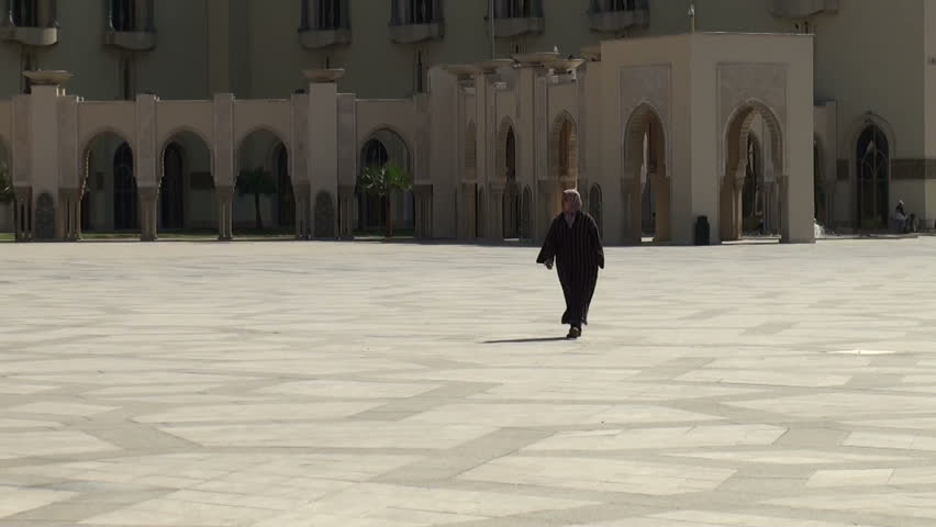 CASABLANCA, MOROCCO - MARCH 12: A Muslim middle-aged woman walks on a square near Hassan II Mosque on March 12, 2011 in Casablanca, Morocco. She is wearing a traditional Islamic dress.