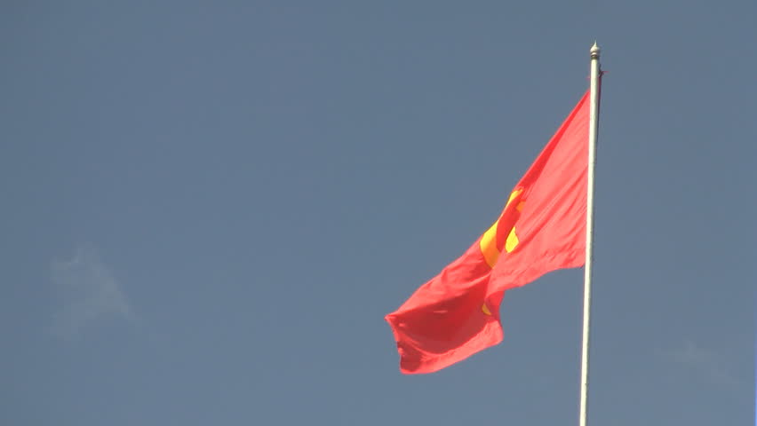 Communist flag waving against blue sky in Vientiane Laos  