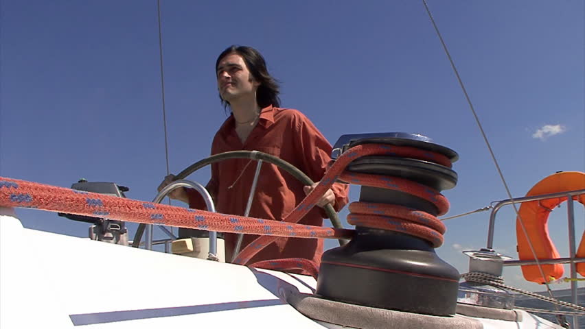Man steering wheel of the sailboat