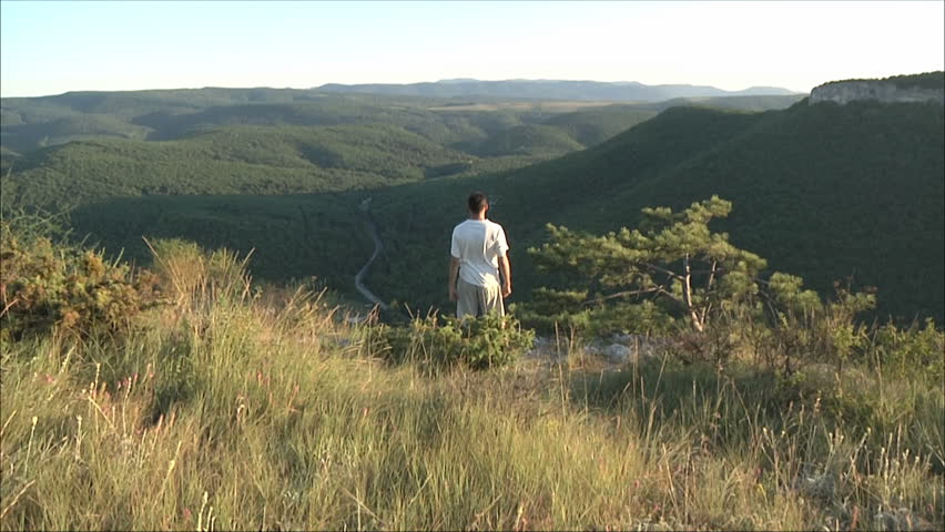 man engaged in gymnastics in the mountains