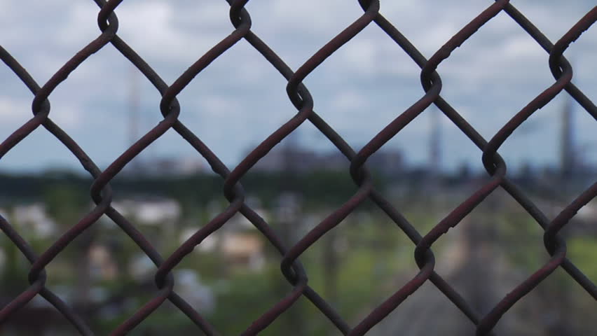 Industrial factory through a metal lattice.