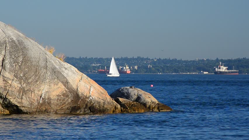 Sailboat and jet crossing in Lighthouse Park at West Vancouver, Canada.