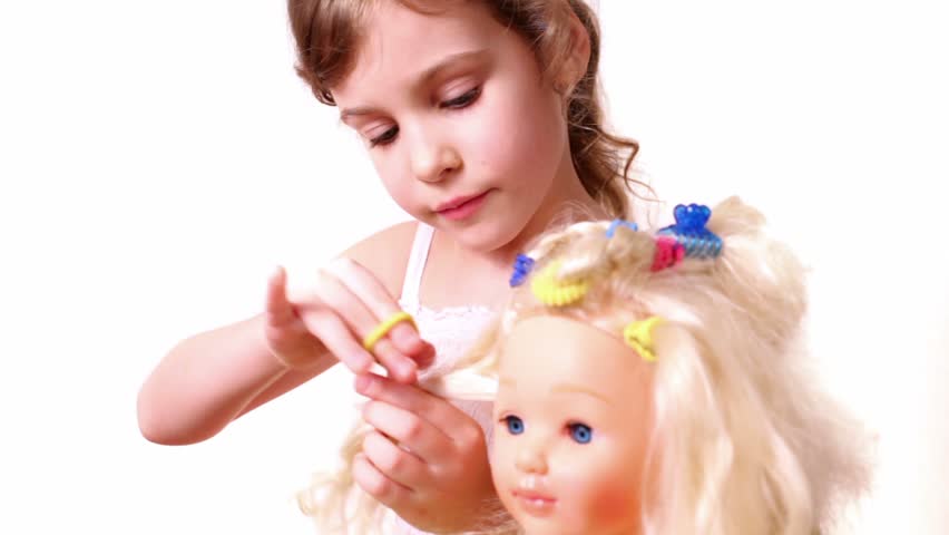 Little girl use elastic band to make dolls hairdo, isolated on white background