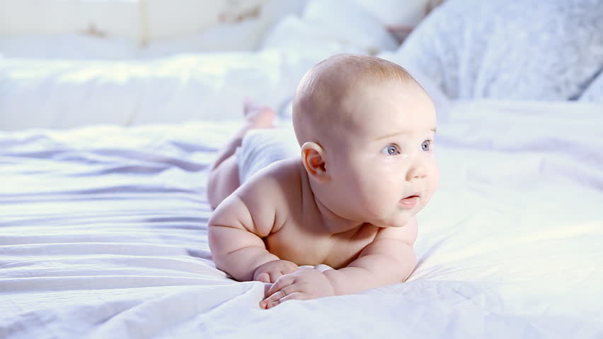 Happy baby rolling on the bed