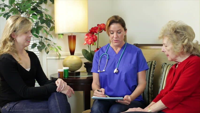 A pretty home health nurse going over prescriptions with an elderly client.