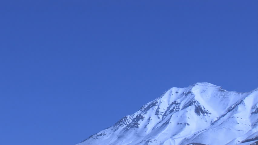 Timpanogos Mountain in  Wasatch Range, part of the Rocky Mountains in central Utah. Summit height of 11,749 feet above sea level. Pan to right of bright blue skies and snow covered peaks. 