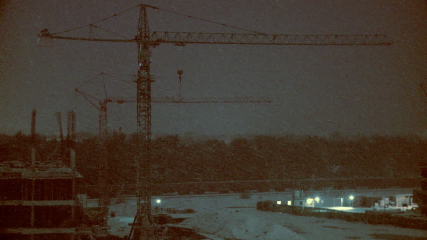 Construction site at night while snow falls