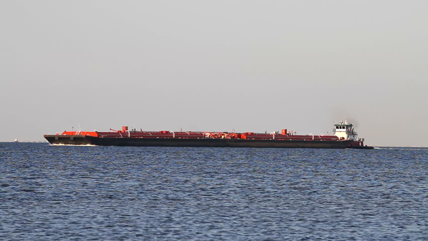 Tugboat pushes a barge along part of the inter coastal waterway on Pensacola Bay, Florida.