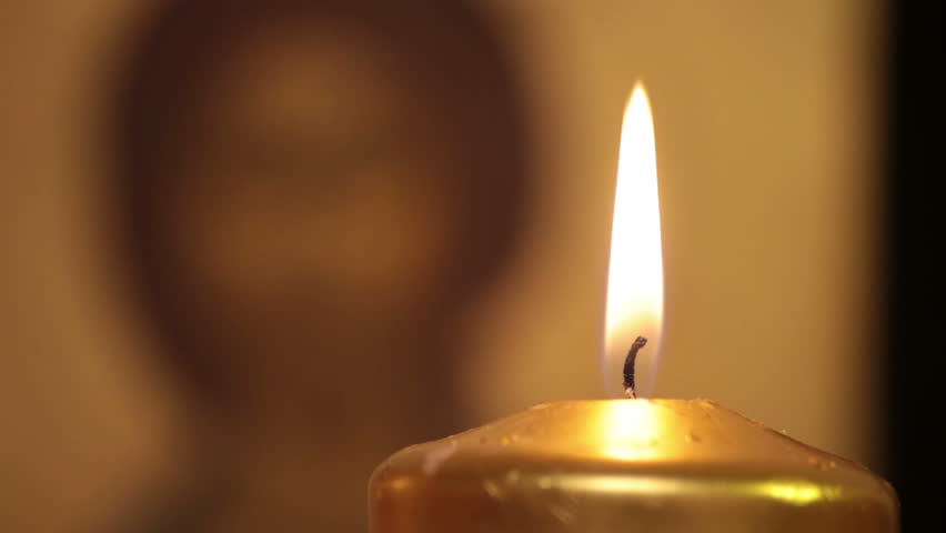 Jesus Christ icon and burning candle. Rack Focus.

