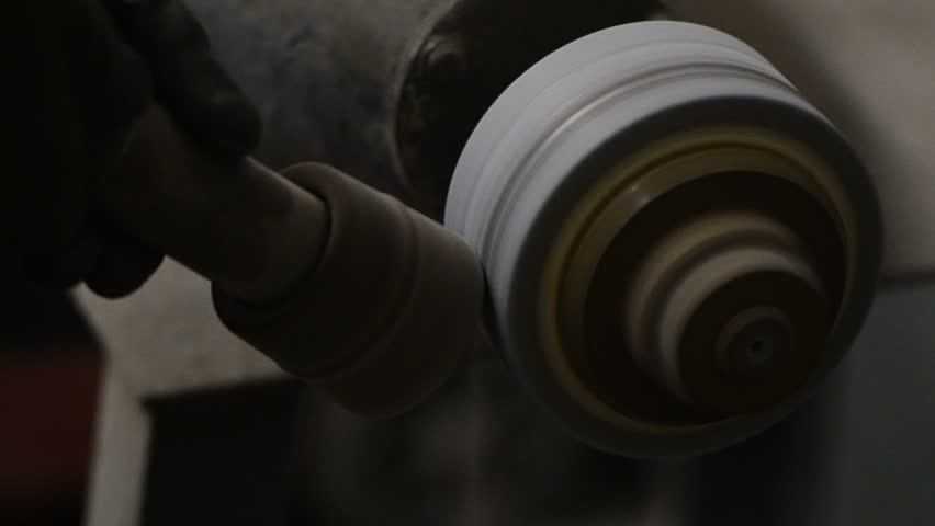 Grinding a steel rod for a tool on a high speed grinding wheel. Sparks fly from hot metal.