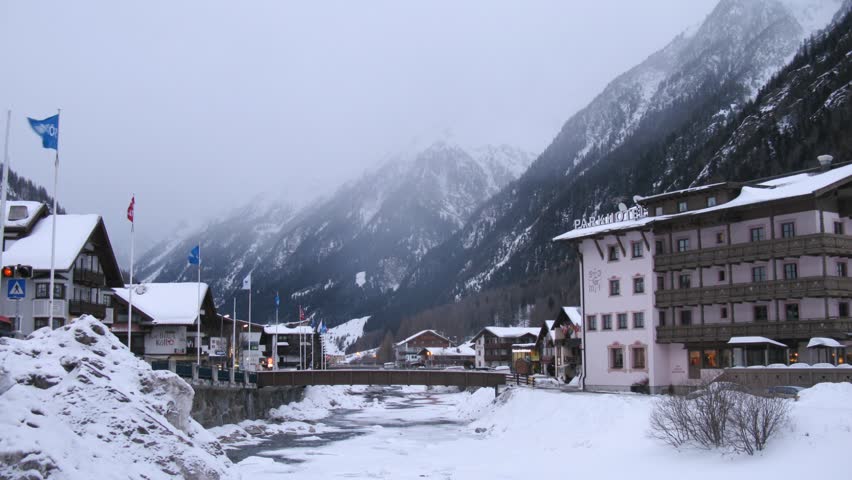 SOELDEN - FEB 15: (Timelapse View) Hotels stand on either side of river which has become covered by ice, on Feb 15, 2012 in Soelden, Austria